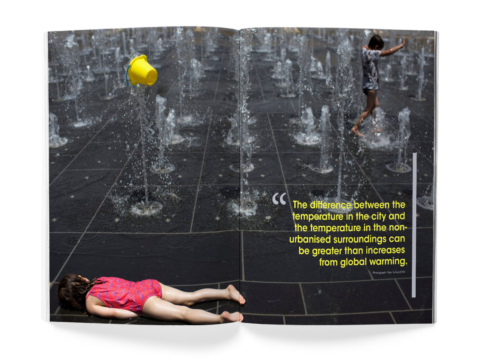 Full page photo spread of young girl facedown in a splash park.